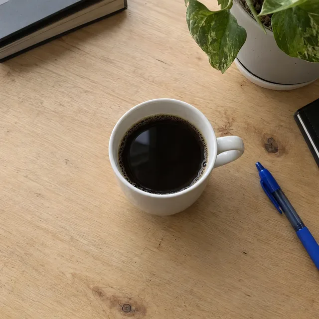 The same mug on a clean wooden desk, nearly identical to the other result